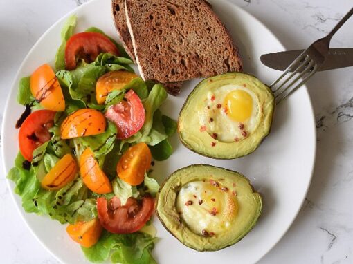 Bagt Avocado med Æg og Salat på hvid tallerken