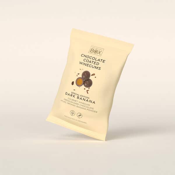 Beige pose med chokoladeovertrukne vingummier og mørk banan, gourmet chokolade og bananpulver.