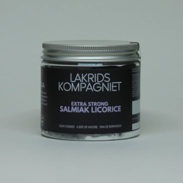 Glaskrukke med sølvlåg, sort label, hvid tekst: "Ekstra stærk salmiak lakrids", fra Lakrids Kompagniet.